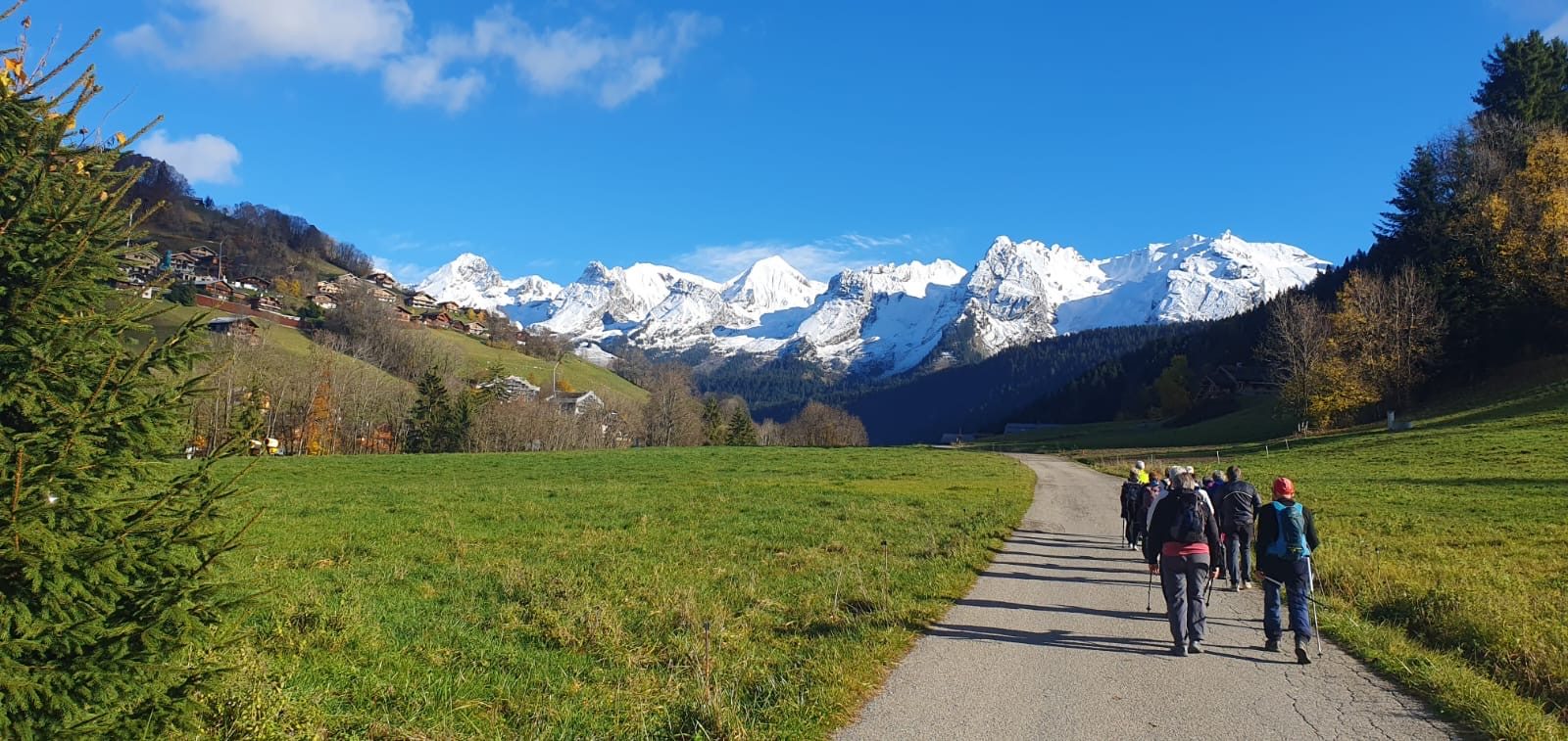 Groupe de randonneurs marchant vers les sommets enneigés des Aravis